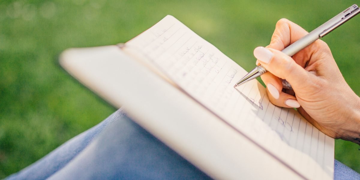 A person writing in a journal, actively reflecting on their feelings and experiences to build self-understanding.