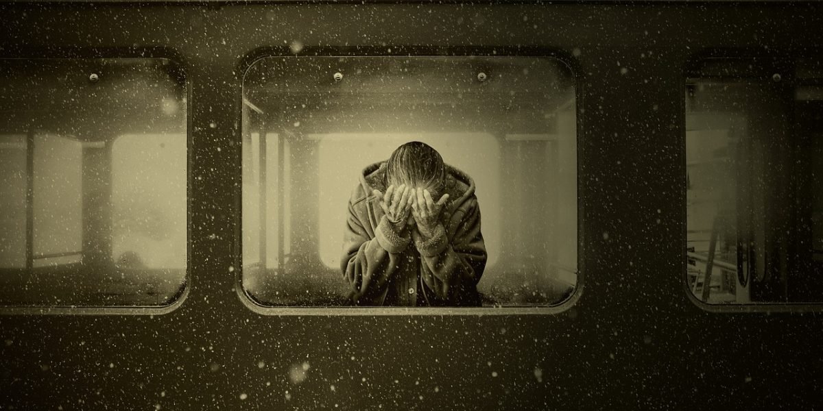 A person looking introspective or sad, reflecting the challenges of living with mental health stigma.
