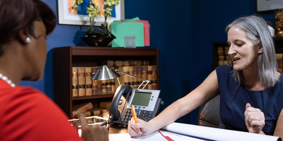 A legal professional engaged in a serious conversation with a client, demonstrating dedication to advocacy.