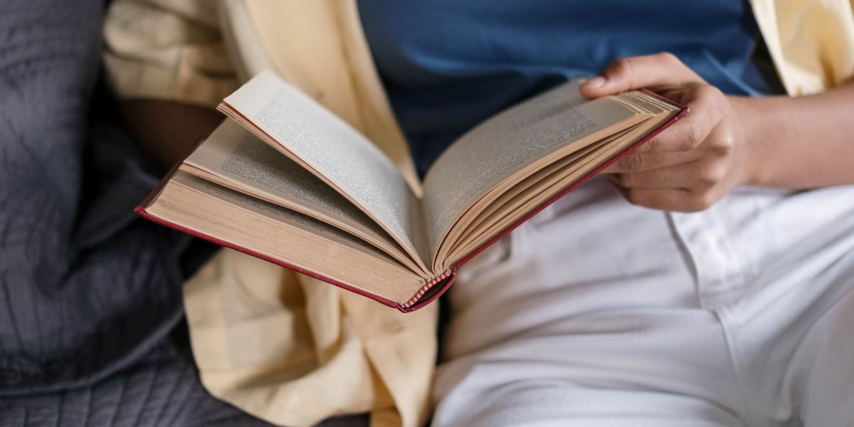 A person enjoys a moment of quiet reading, highlighting the joy and relaxation that books bring to daily life.