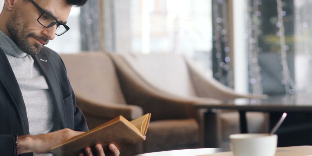A person enjoys reading on a tablet in a relaxed setting, illustrating the convenience of digital reading apps across devices.