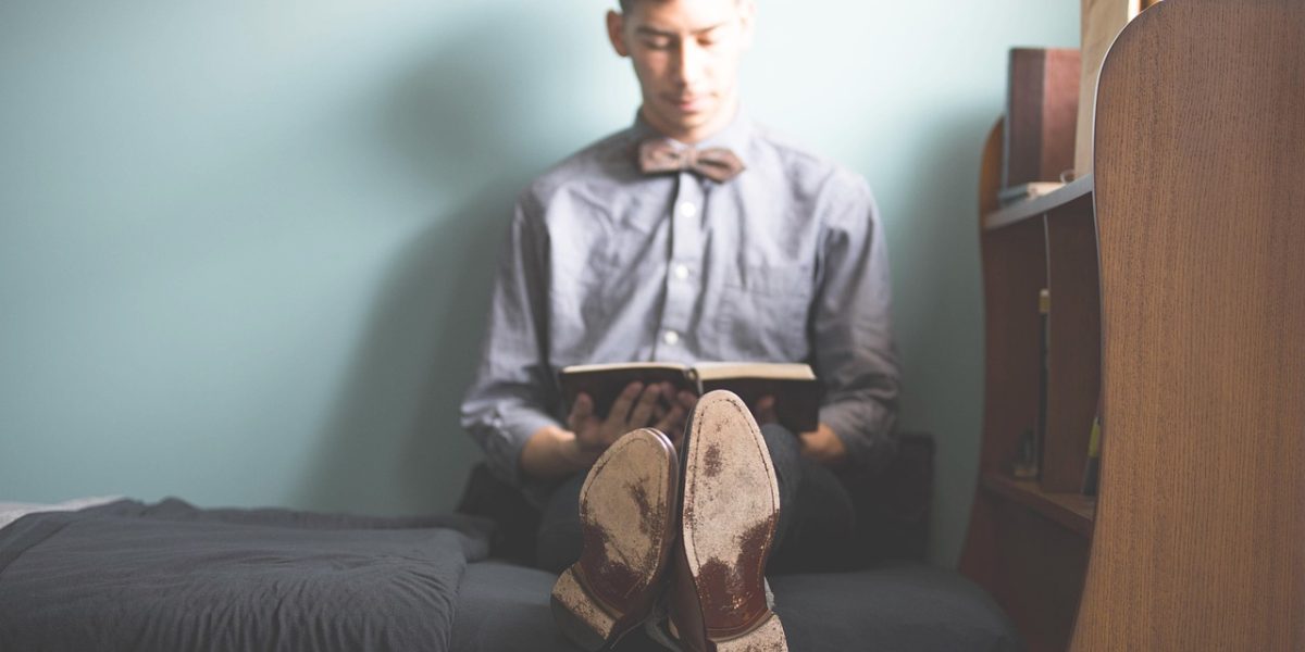 A person immersed in reading, reflecting on the profound messages within a captivating book.