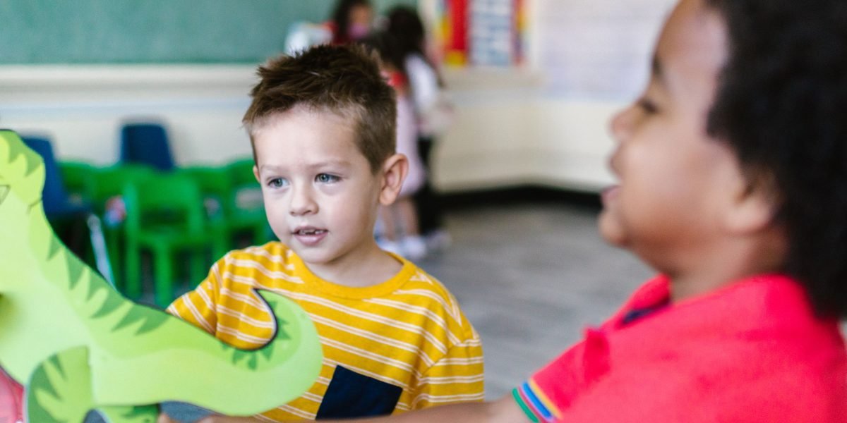 Children playing together, sharing toys, symbolizing the development of empathy and social skills learned through stories.