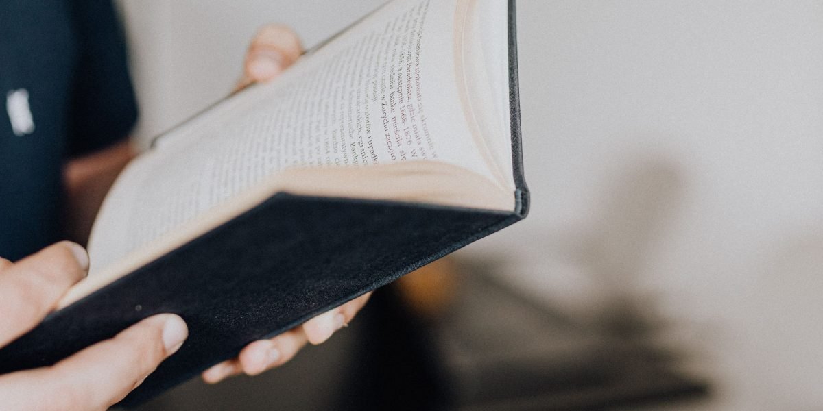 A person engrossed in a book, embodying the quiet focus of 'open book' thinking.