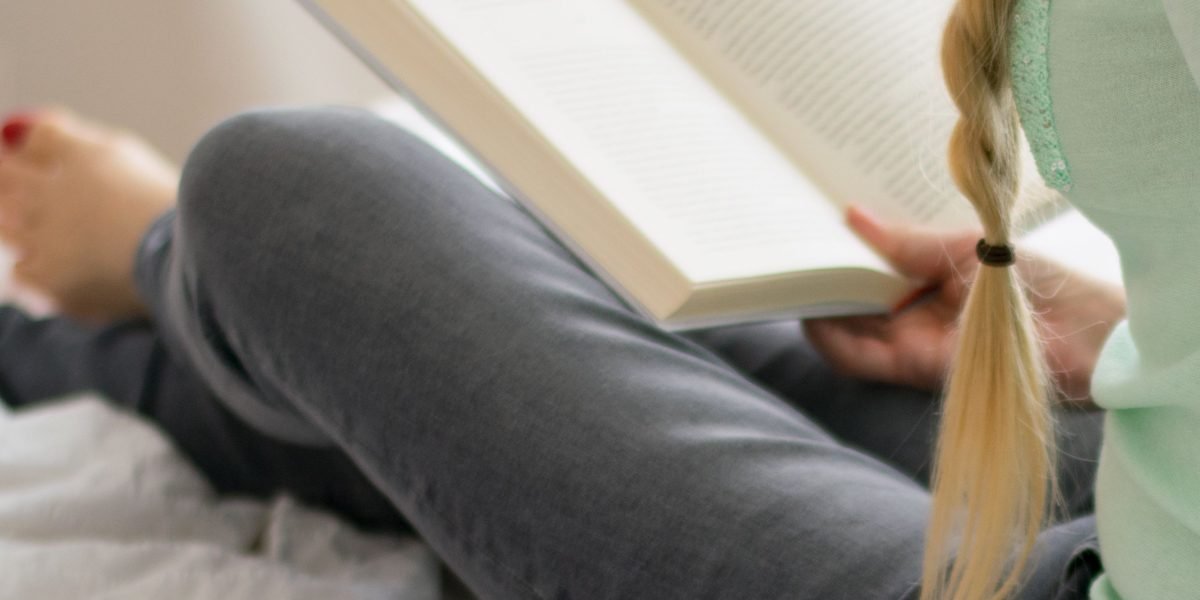 A person engrossed in a book, highlighting the simple pleasure of reading.
