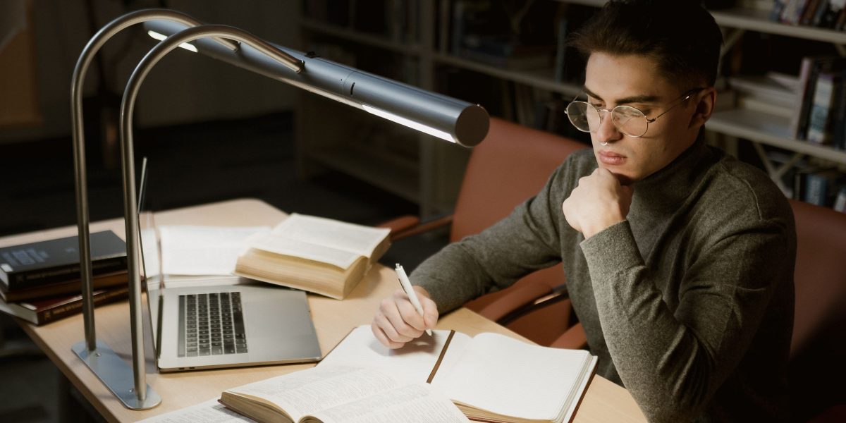 A focused individual researching among shelves, symbolizing the exploration of legal concepts.