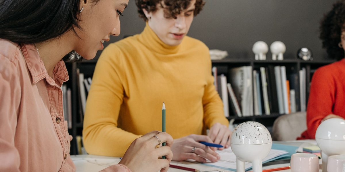 A small team discusses ideas around a table, representing the hybrid workflow of AI and human collaboration in audiobook creation.