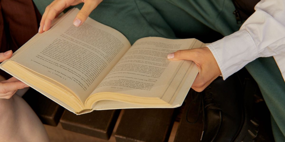 Friends gather to enjoy a book together, highlighting the communal aspect of reading.