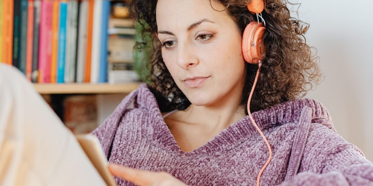 A person listening to an audiobook with headphones while engaged in an everyday activity, demonstrating flexible reading habits.