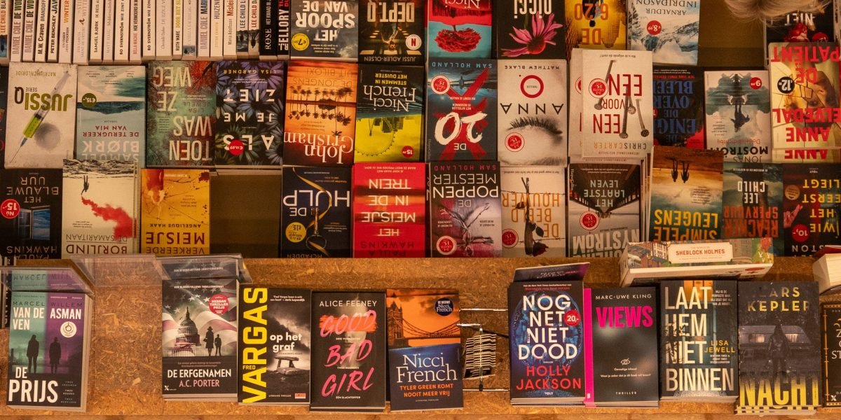 A person enjoys the tactile experience of browsing various titles at a vibrant book fair.