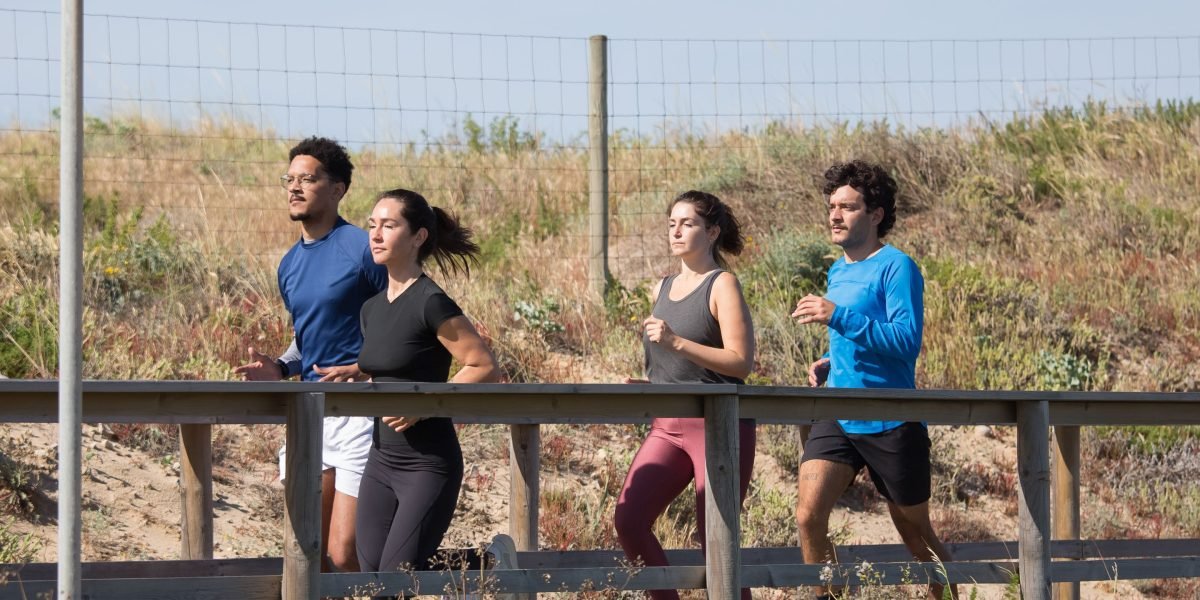 A diverse group of friends enjoying a run together in a park, highlighting the social and community aspect of fitness.
