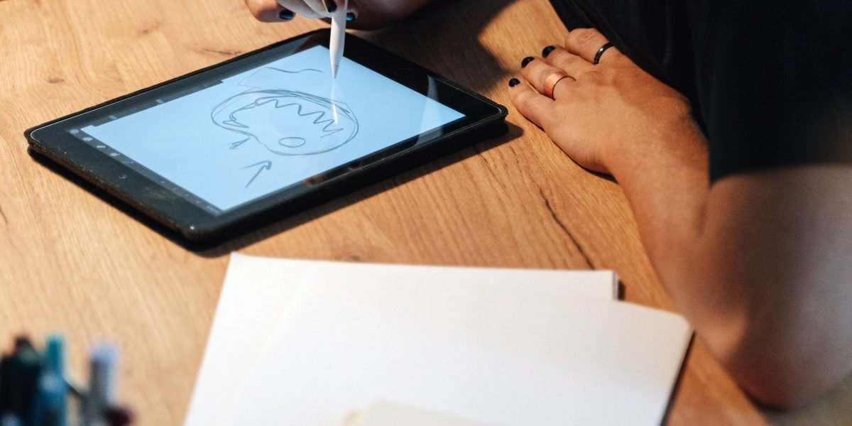A person engrossed in sketching ideas, representing the creative output fostered by pixel games and micro-routines.